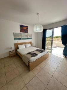 une chambre avec un grand lit et une grande fenêtre dans l'établissement Nissi Beach Escape - 5 Min Walk to Paradise, à Ayia Napa 42 autres photos