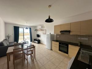 une cuisine et un salon avec une table et des chaises dans l'établissement Nissi Beach Escape - 5 Min Walk to Paradise, à Ayia Napa