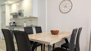 ein Esszimmer mit einem Holztisch und schwarzen Stühlen in der Unterkunft MIRADOR lovely apartment in Benidorm