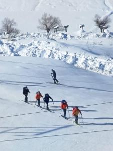 a group of people skiing down a snow covered slope at Gangzing Homestay in Tāndi