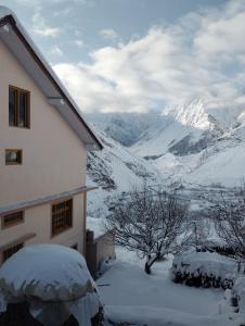 a snow covered house with a view of a mountain at Gangzing Homestay in Tāndi