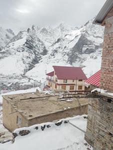 a building with a snow covered mountain in the background at Gangzing Homestay in Tāndi