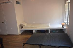 a room with a bench with a mattress on it at Lemonia apartment Old Town in Corfu