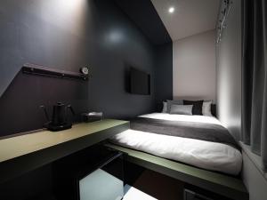 東京にあるOCICA OSHIAGE TOKYO by R HOTELのベッドとテレビ付きの机のある寝室 +36枚の写真