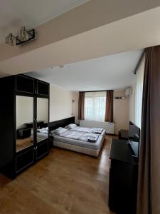 a bedroom with a bed and a desk in it at Хотел Валентино 2 in Dobrinishte