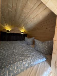 un letto in una stanza con soffitto in legno di Schlaffass am Sund ad Altefähr