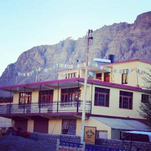 a large building with a mountain in the background at Spitihome homestay in Kaja