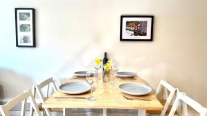 a wooden table with white plates and glasses on it at La'l Stenkrith in Kirkby Stephen +15 photos