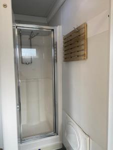 a shower in a bathroom with a glass door at The River Thames - Surrey Boat in Thorpe