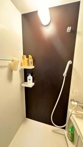 a bathroom with a shower with a black wall at 旅人の家 Entire貸切日式民宿 JR南柏駅 新柏駅 高速WiFi アメニティ完備 フルキッチン 洗濯機 上野駅30分 成田空港60分 in Kashiwa +56 photos