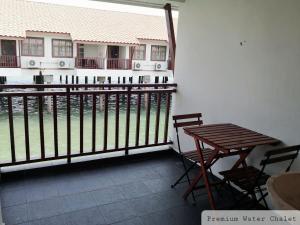 a balcony with a table and chairs and a fence at Alpine Premium Water Chalet 2 in Port Dickson