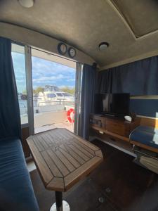 a living room with a table and a view of a boat at The River Thames - Surrey Boat in Thorpe