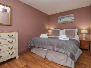 une chambre avec un lit avec deux lampes et une commode dans l'établissement The Cottage, à Thirsk