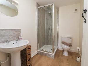 une salle de bain avec douche, lavabo et toilettes dans l'établissement The Cottage, à Thirsk 17 autres photos