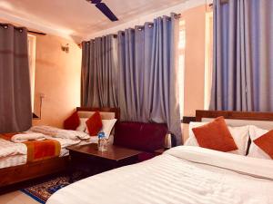 una camera d'albergo con due letti e un tavolo di Om Mandakini Hotel a Kathmandu