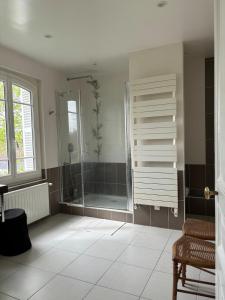Un baño con ducha con puerta de cristal. en Cosy villa, near beach, en Touques