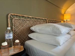 Una cama con almohadas y una botella de agua en una mesa. en Cosy villa, near beach, en Touques