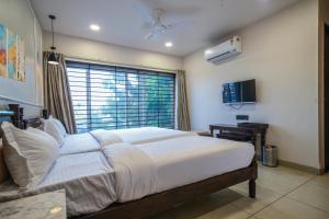 a bedroom with a large bed and a window at The Byke Boutique Mahakal Aangan - Pan India Pure Veg Hotel Chain in Ujjain
