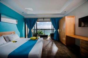 a bedroom with a large bed and a large window at Residenceticoco in Grand-Baie