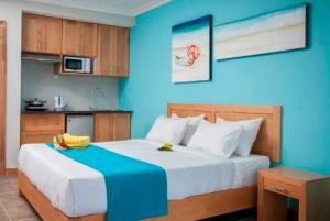 a bedroom with a large bed with a blue wall at Residenceticoco in Grand Baie +7 photos