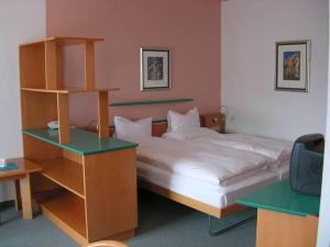 Schlafzimmer mit einem Bett und einem Schreibtisch mit einem TV in der Unterkunft Hotel Marko in Nötsch