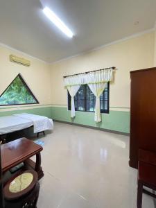 a hospital room with two beds and a window at Villa THỦY NGUYÊN in Bình Thủy +3 photos