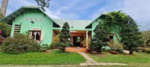 a green house with a green roof at Villa THỦY NGUYÊN in Bình Thủy