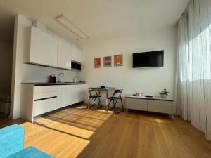 een keuken met witte kasten en een tafel met stoelen bij GioLu Colosseo in Rome