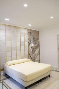 a bedroom with a bed with a painting on the wall at Dimora delle Storie in Tempio Pausania