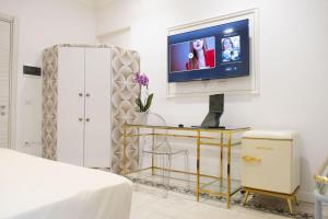 a living room with a tv and a table with a bed at Dimora delle Storie in Tempio Pausania