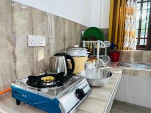 a kitchen with a stove top oven on a counter at Shanthi Apartments in Anuradhapura