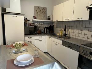 a kitchen with white cabinets and a table with plates on it at Regenbogengasse in Schkeuditz