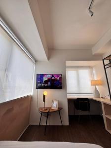 a bedroom with a desk and a table and a window at Cozy Cove - Avida Aspira Tower 1 in Cagayan de Oro