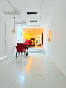 a dining room with a table and red chairs at Hotel Tulip Inn, Gulberg in Lahore