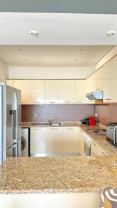 HarqalahにあるApartment with panoramic sea viewsのキッチン(白いキャビネット、花崗岩のカウンタートップ付)
