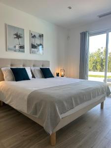 una camera da letto con un letto grande con una grande finestra di Villa neuve avec piscine 3 chambres 140 m2 a Calvi Altre 24 foto