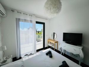 sypialnia z łóżkiem, telewizorem i oknem w obiekcie Villa Livia Porticcio piscine 500m plage w mieście Porticcio +37 zdjęć