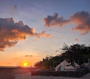 a sunset on the beach with the sun setting at KAWAI Beach Camp in Lobo