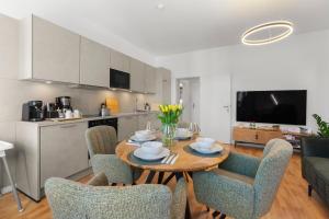 a kitchen and living room with a table and chairs at ElbDreams Cozy Design Apartment in Dresden