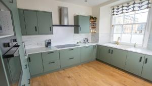 a kitchen with green cabinets and white counter tops at Elegant 3BD Georgian Retreat in Perth City Centre in Perth
