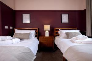 two beds in a room with purple walls at Elegant 3BD Georgian Retreat in Perth City Centre in Perth