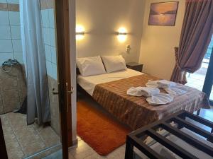 a bedroom with a bed with towels on it at Apolis hotel in Mouzaki +21 photos