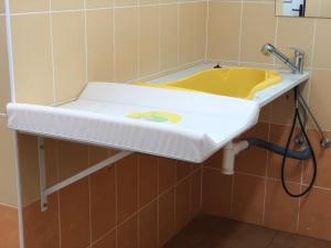un bagno con un lavandino giallo nel muro di Woodland Cabin Camping de Regenboog a Šluknov