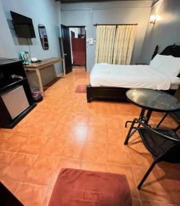 a bedroom with a bed and a table and a chair at Local Guesthouse in Vang Vieng