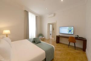 una camera da letto con un letto e una scrivania con una televisione di AGH Babuino a Roma