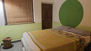 a bedroom with a bed with a green wall at Laxmi Happy Home in Querim Goa in Querim