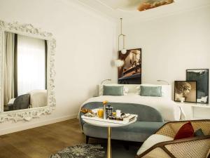 a bedroom with a bed and a table and a mirror at Sofitel Roma Villa Borghese in Rome