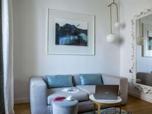 a living room with a couch and a laptop on a table at Sofitel Roma Villa Borghese in Rome
