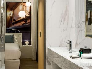 a bathroom with a sink and a bed at Sofitel Roma Villa Borghese in Rome