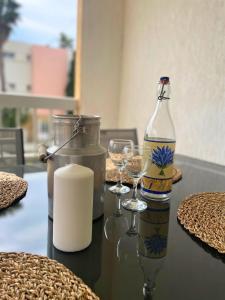 a table with a bottle and two glasses on it at Echappée Marine - Plage du Grau-du-Roi in Le Grau-du-Roi +16 photos